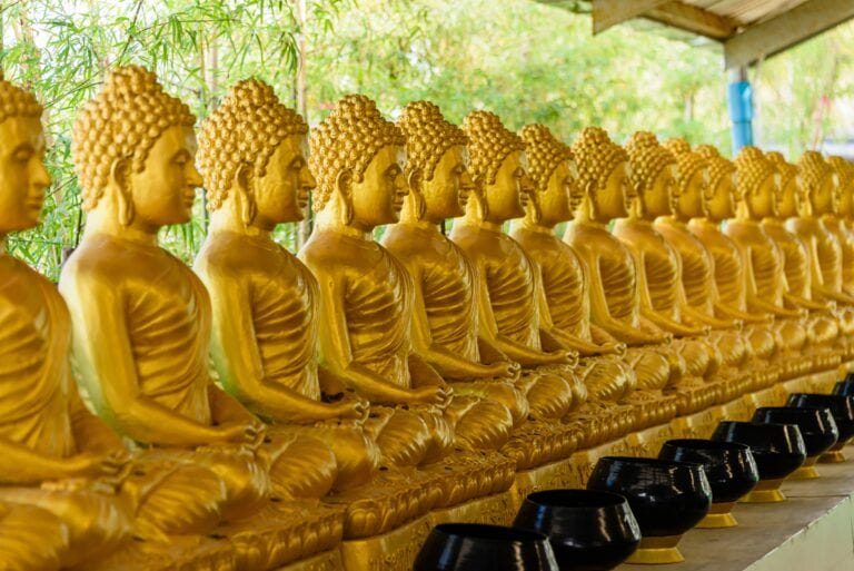 A row of golden buddha statues at Big Buddha in Phuket, Thailand