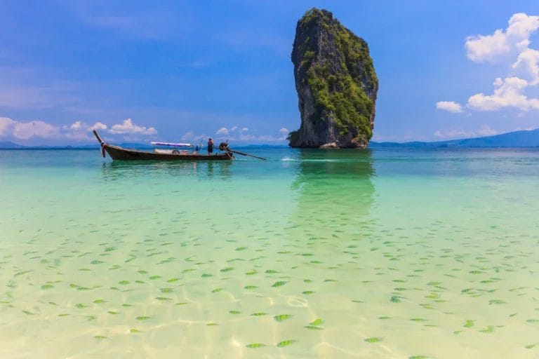 Mu-Kho-Poda near Phi Phi Islands a boat by a single island with a lots of fish in light green ocean